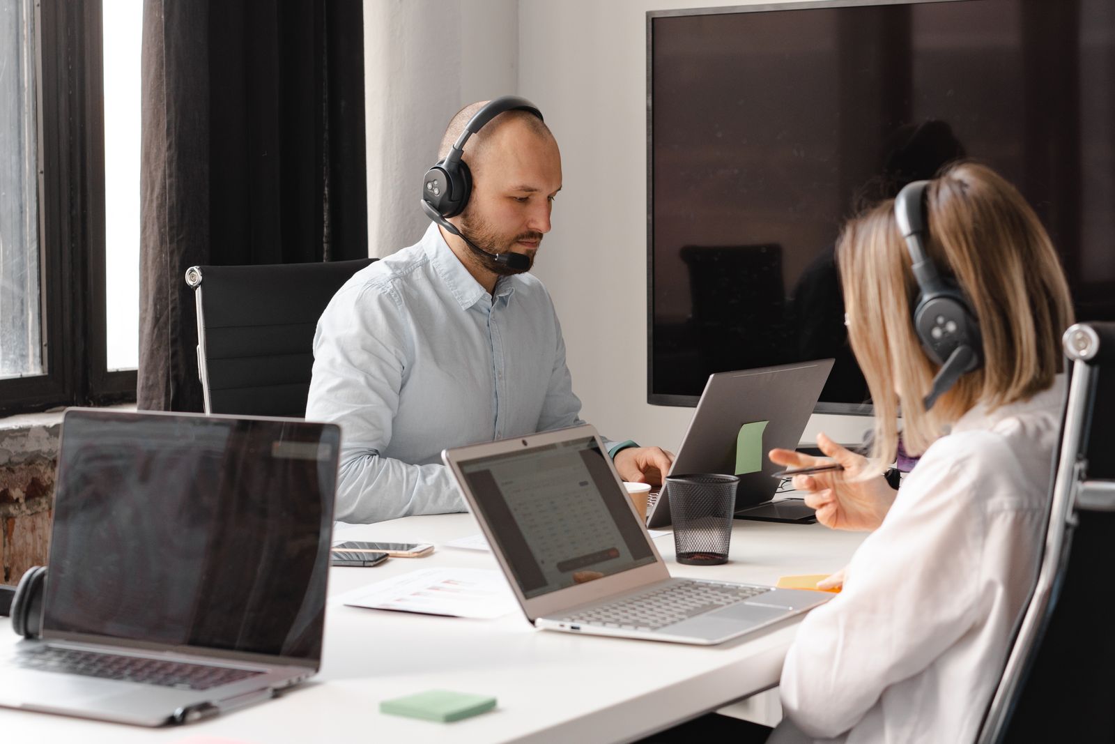 Technology support team working with laptops and headsets